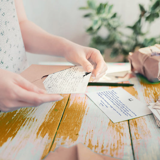 why handwrite a letter? Woman opening a handwritten letter